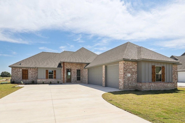 4007 Aerie St, Salado, TX 76571 - view of front of home with brick siding, an attached garage, a shingled roof, driveway, and a front yard