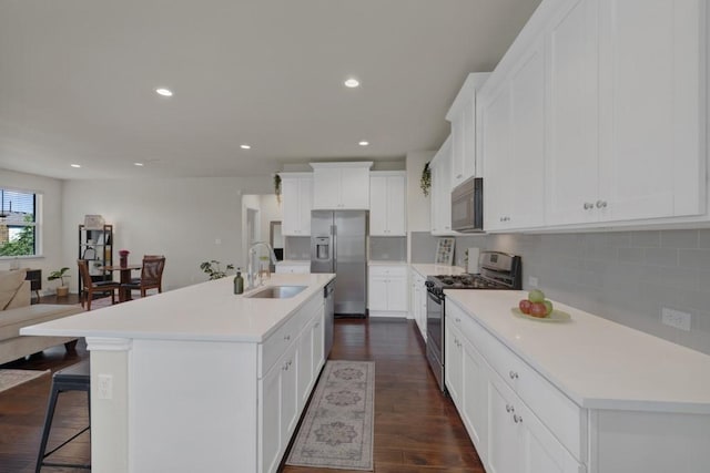 106 Mary Max Cv, San Marcos, TX 78666 - kitchen featuring stainless steel appliances, a sink, a kitchen bar, decorative backsplash, and light countertops