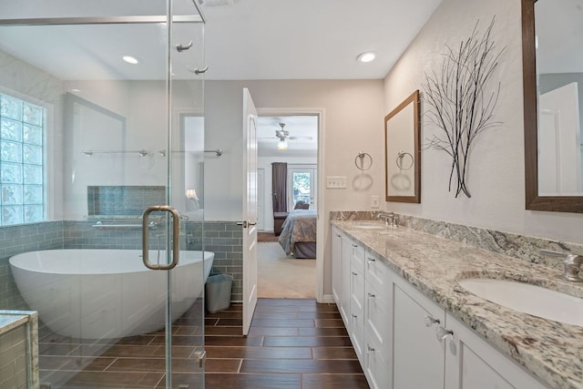 10109 Vaquero Trl, Austin, TX 78759 - bathroom with tile walls, a ceiling fan, a freestanding bath, double vanity, and ensuite bathroom
