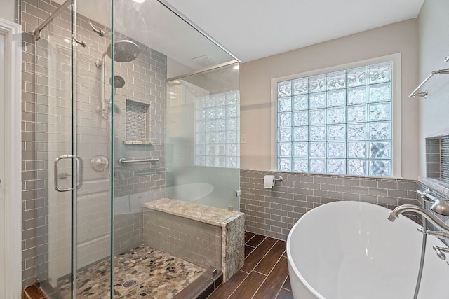 10109 Vaquero Trl, Austin, TX 78759 - full bathroom featuring a soaking tub, a shower stall, tile walls, wood tiled floors, and a sink
