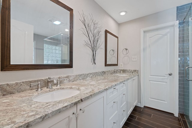 10109 Vaquero Trl, Austin, TX 78759 - bathroom featuring a stall shower, double vanity, and wood finished floors