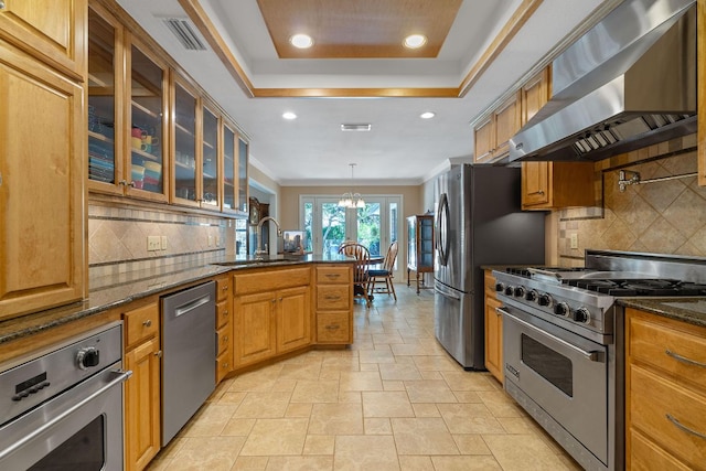 10109 Vaquero Trl, Austin, TX 78759 - kitchen with stainless steel appliances, wall chimney range hood, a sink, a peninsula, and backsplash