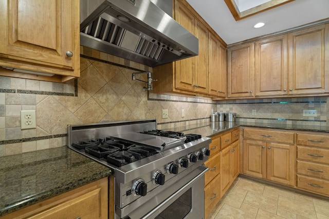 10109 Vaquero Trl, Austin, TX 78759 - kitchen featuring high end stainless steel range, extractor fan, tasteful backsplash, brown cabinetry, and dark stone counters