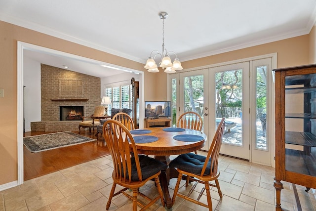 10109 Vaquero Trl, Austin, TX 78759 - dining area featuring stone tile floors, a brick fireplace, french doors, a chandelier, and ornamental molding