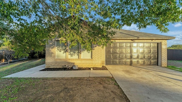 view of front facade featuring brick siding, concrete driveway, an attached garage, and fence