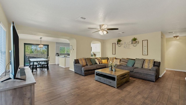 1131 Stone Trl, New Braunfels, TX 78130 - living room featuring arched walkways, dark wood-style flooring, ceiling fan, and baseboards
