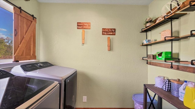 laundry area with washer and clothes dryer and a barn door