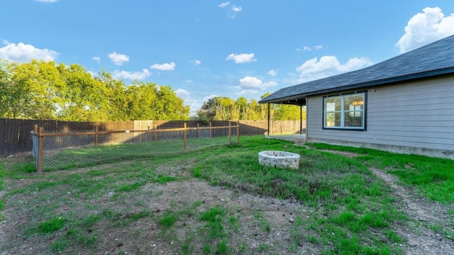 fenced backyard with a fire pit