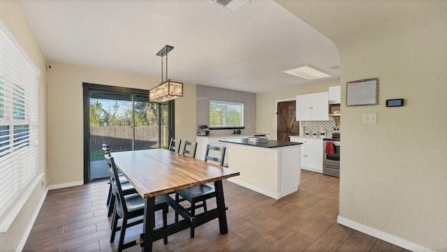 1131 Stone Trl, New Braunfels, TX 78130 - dining area featuring dark wood-type flooring, baseboards, a textured ceiling, and a chandelier