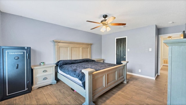 bedroom with light wood-style flooring, baseboards, and a ceiling fan