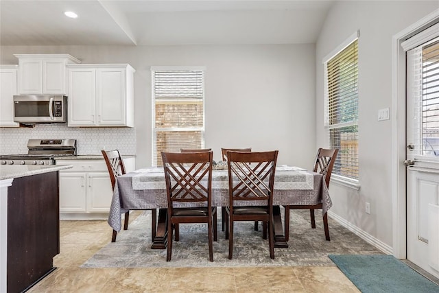 dining space with plenty of natural light, light tile patterned floors, baseboards, and recessed lighting