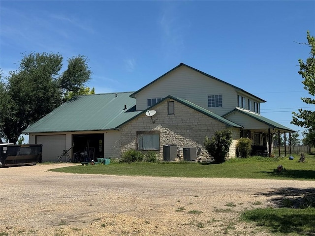 21424 Martin Ln, Pflugerville, TX 78660 - back of house with central AC, driveway, stone siding, and an attached garage