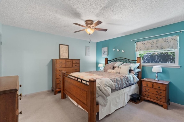 bedroom with light carpet, a textured ceiling, ceiling fan, and baseboards
