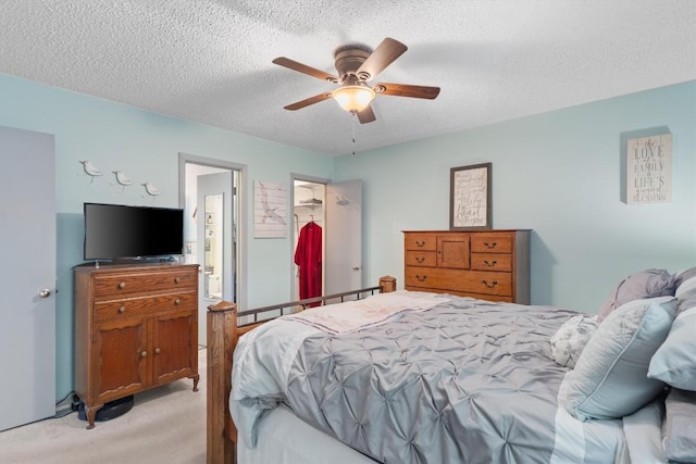 bedroom featuring light carpet, a textured ceiling, and ceiling fan
