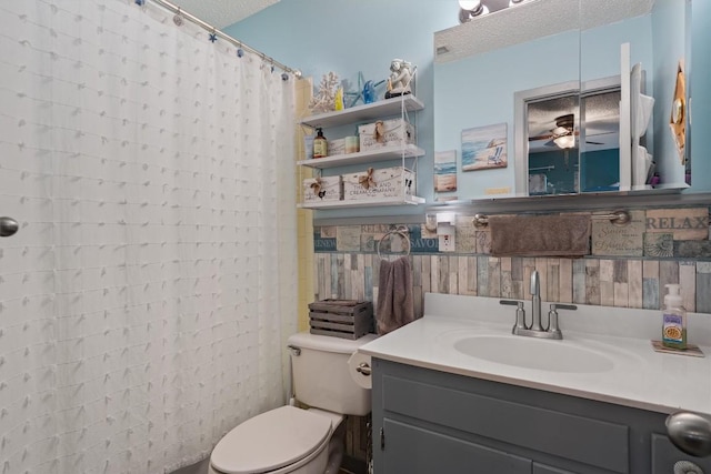bathroom featuring a textured ceiling, ceiling fan, vanity, toilet, and a shower with curtain