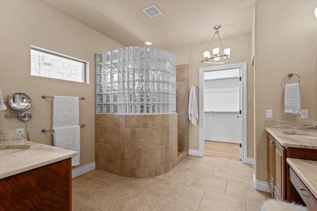 5124 Hidden Springs Trl, Georgetown, TX 78633 - full bathroom featuring a walk in shower, two vanities, tile patterned floors, a chandelier, and baseboards