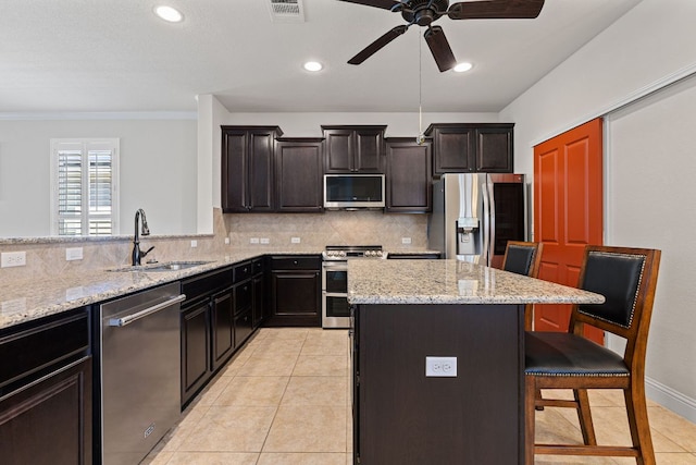126 Cathedral Mountain Pass, Georgetown, TX 78633 - kitchen with stainless steel appliances, a sink, a breakfast bar area, decorative backsplash, and recessed lighting
