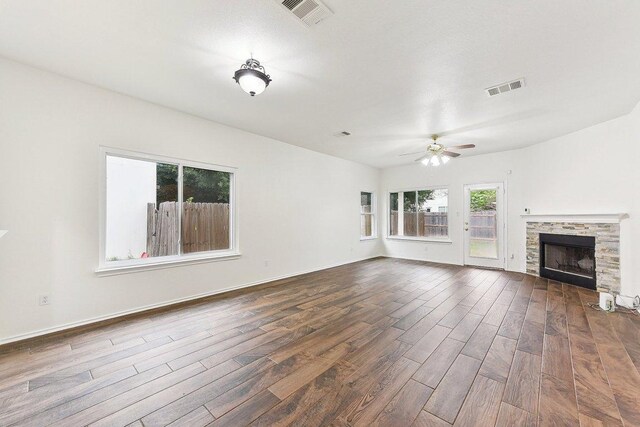 13213 Marie Ln, Manor, TX 78653 - unfurnished living room featuring dark wood-type flooring, a ceiling fan, a tiled fireplace, and baseboards