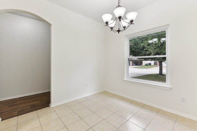 13213 Marie Ln, Manor, TX 78653 - unfurnished room with arched walkways, a chandelier, light tile patterned flooring, and baseboards