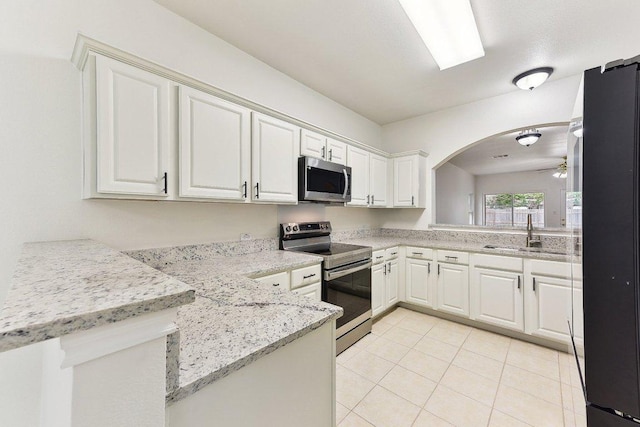 13213 Marie Ln, Manor, TX 78653 - kitchen with stainless steel appliances, a sink, a ceiling fan, a peninsula, and white cabinetry