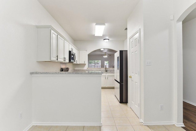 13213 Marie Ln, Manor, TX 78653 - kitchen with freestanding refrigerator, stainless steel microwave, ceiling fan, and white cabinets