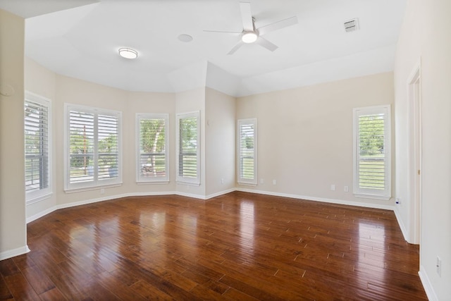 unfurnished room featuring wood finished floors, healthy amount of natural light, ceiling fan, and baseboards