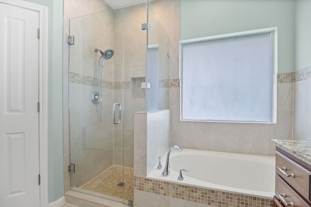full bath featuring a garden tub, a shower stall, and vanity