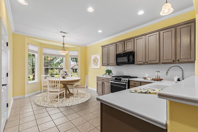 409 Rio Grande Loop, Georgetown, TX 78633 - kitchen featuring stainless steel gas range oven, black microwave, a sink, baseboards, and light tile patterned flooring