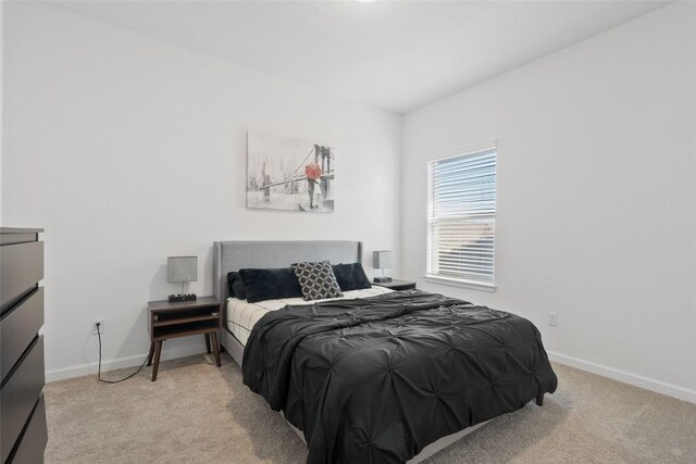 bedroom with light carpet and baseboards
