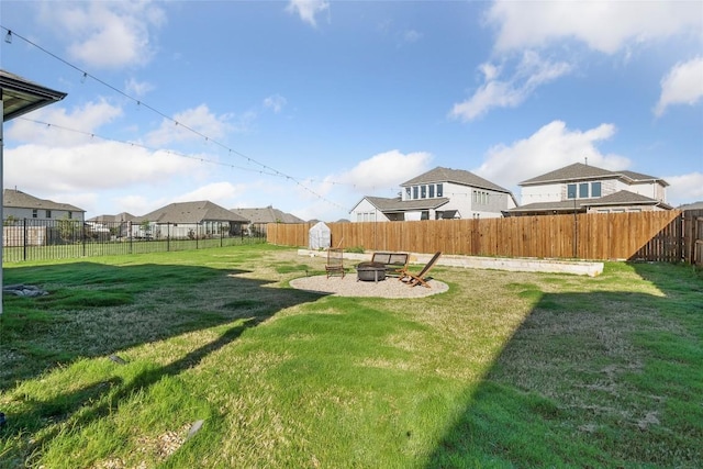 view of yard with a fire pit and a residential view