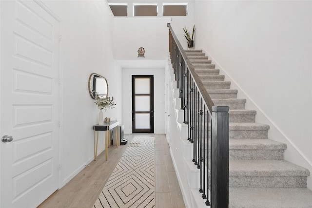 foyer entrance featuring stairs, baseboards, and inlaid floor details