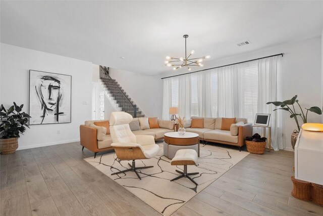 208 Dycus Bnd, Liberty Hill, TX 78642 - living room featuring a chandelier, wood finished floors, and stairs