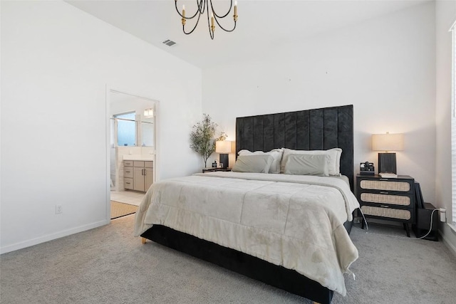 carpeted bedroom featuring a chandelier, baseboards, and ensuite bath