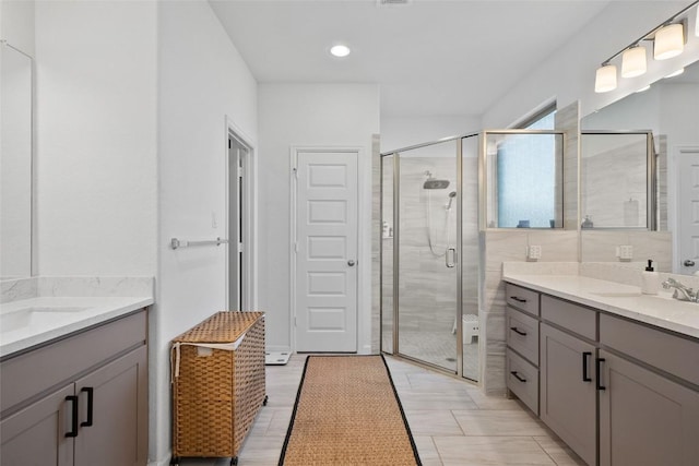 full bathroom with a stall shower and two vanities