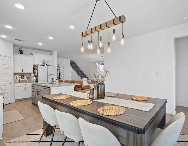 dining room with stairway, recessed lighting, and light wood finished floors