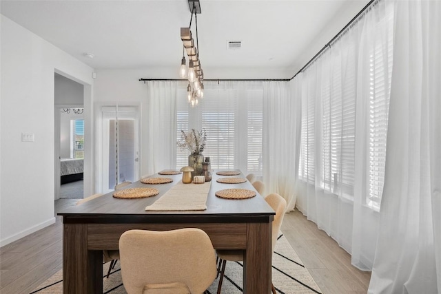 dining area featuring light wood-style flooring and baseboards