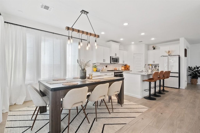 dining room with light wood-style flooring and recessed lighting