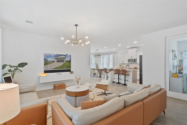 208 Dycus Bnd, Liberty Hill, TX 78642 - living area with a chandelier, light wood-style flooring, and recessed lighting