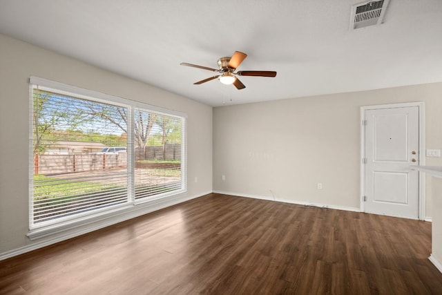 spare room with wood finished floors, ceiling fan, and baseboards