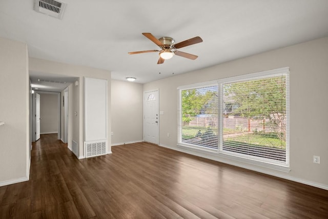 empty room featuring ceiling fan, dark wood-type flooring, and baseboards