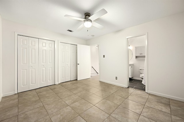 2122 Hancock Dr Unit 103, Austin, TX 78756 - unfurnished bedroom featuring two closets, light tile patterned floors, ensuite bathroom, baseboards, and ceiling fan
