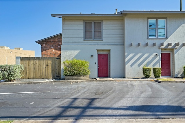 2122 Hancock Dr Unit 103, Austin, TX 78756 - view of property featuring fence, uncovered parking, brick siding, and stucco siding