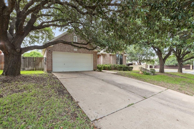 view of front of house featuring brick siding, fence, a garage, and driveway