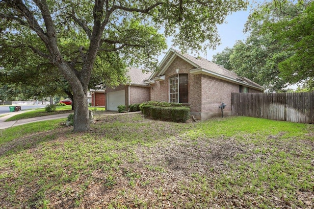 view of side of home with brick siding, fence, and a garage