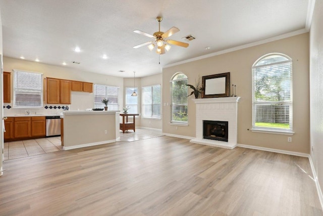 unfurnished living room with light wood finished floors, a sink, a ceiling fan, recessed lighting, and a fireplace