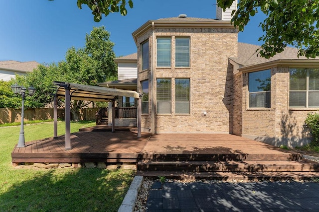 rear view of house with brick siding, a deck, and a chimney
