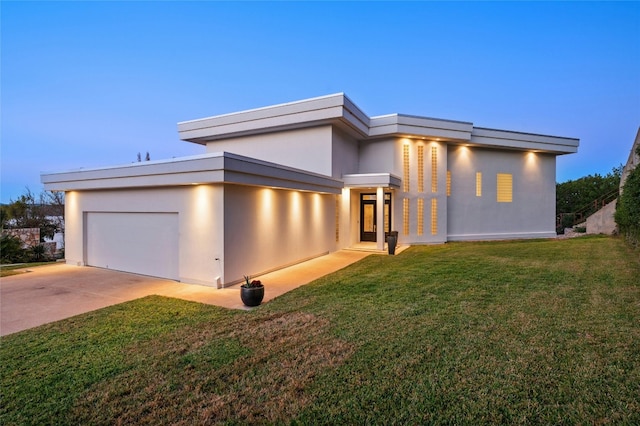 view of front of home featuring a garage, driveway, stucco siding, and a front lawn