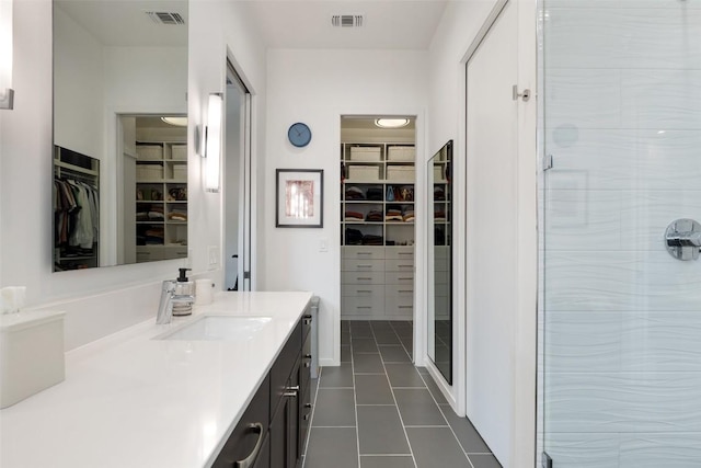 2500 Cedarview Dr, Austin, TX 78704 - bathroom with a walk in closet, vanity, tile patterned flooring, and a stall shower
