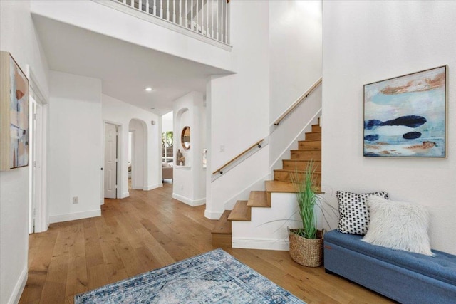 3313 Oxsheer Dr, Austin, TX 78732 - foyer entrance featuring arched walkways, baseboards, stairway, wood finished floors, and a high ceiling