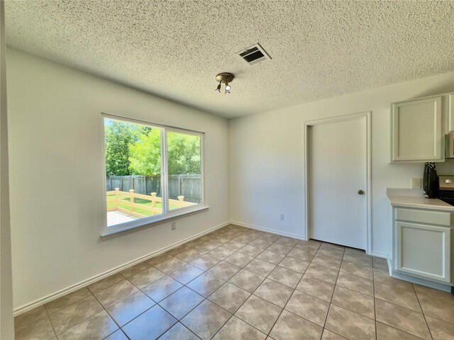 7817 Marble Ridge Dr, Austin, TX 78747 - unfurnished dining area with a textured ceiling and light tile patterned flooring